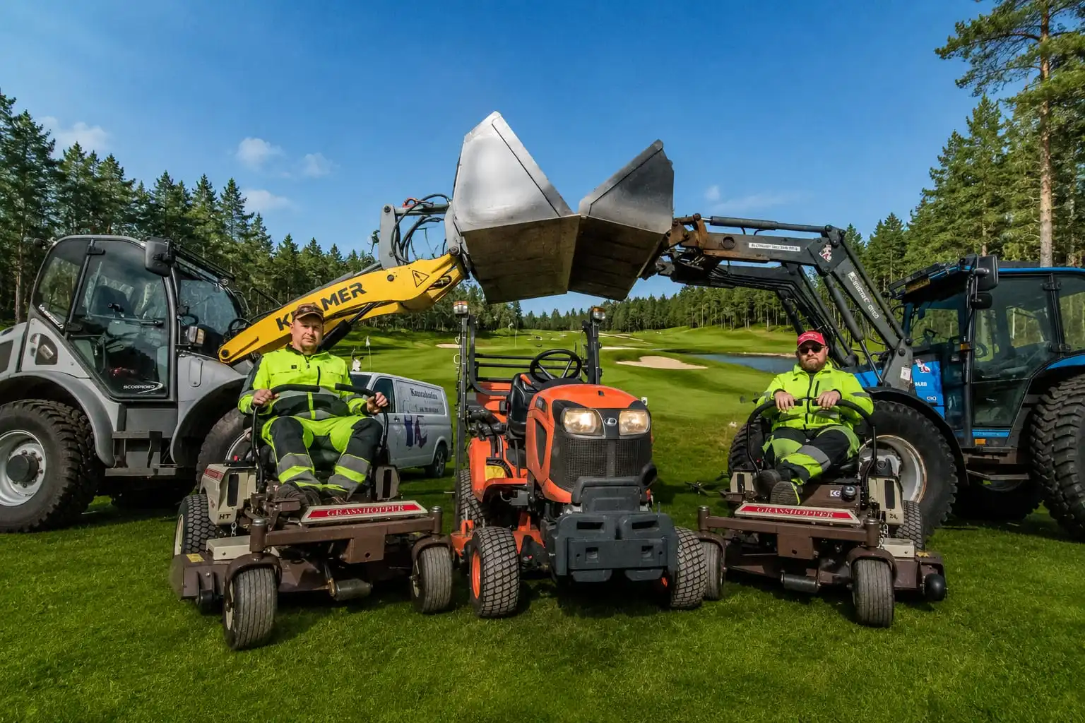 Kaksi Kiteen Kotihuollon työntekijää istuu ruohonleikkureilla kalustonsa keskellä golfkentällä.